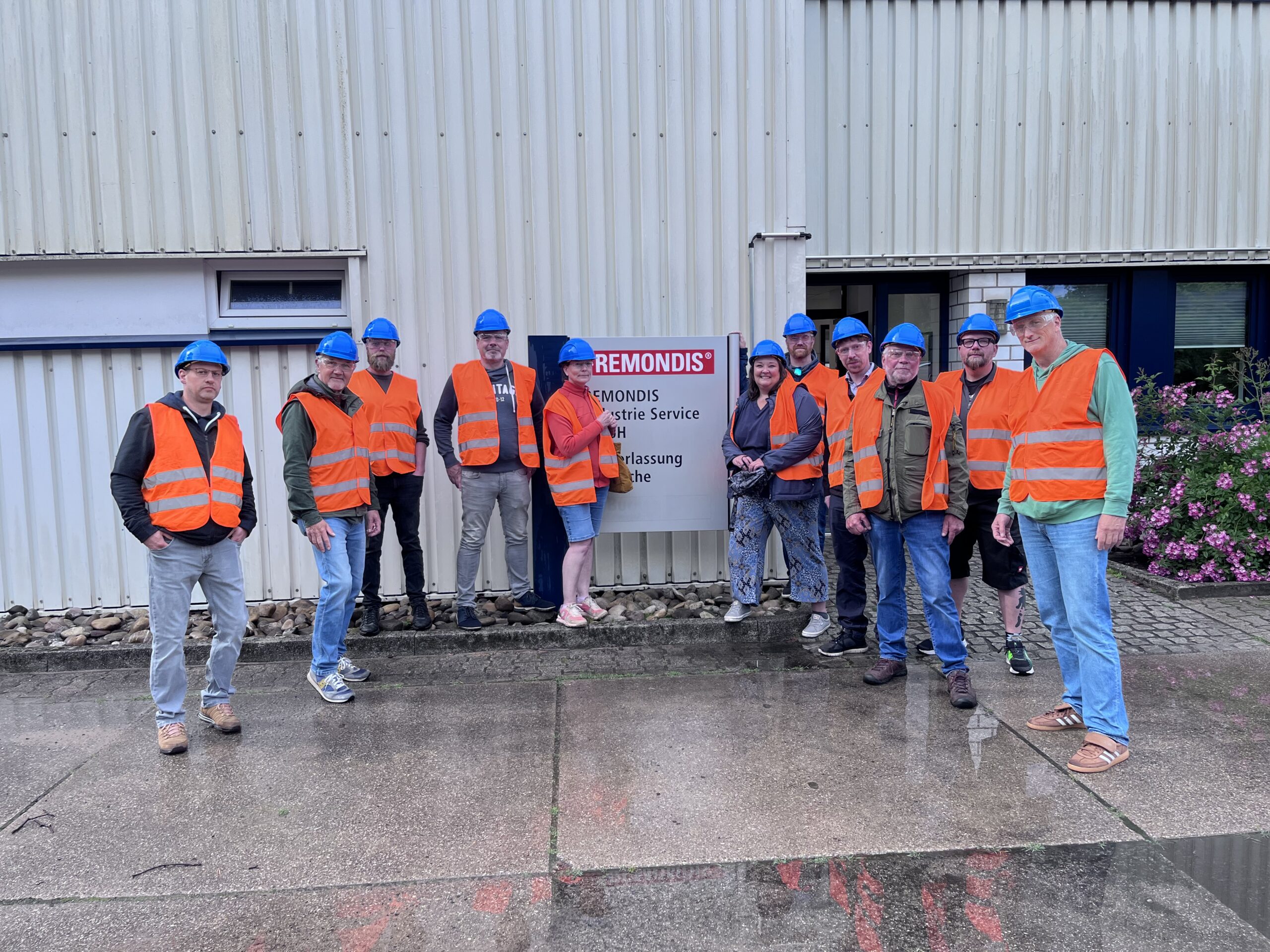 Besuchsgruppe mit Schutzhelmen und Warnwesten vor REMONDIS Industrie Service in Bramsche.